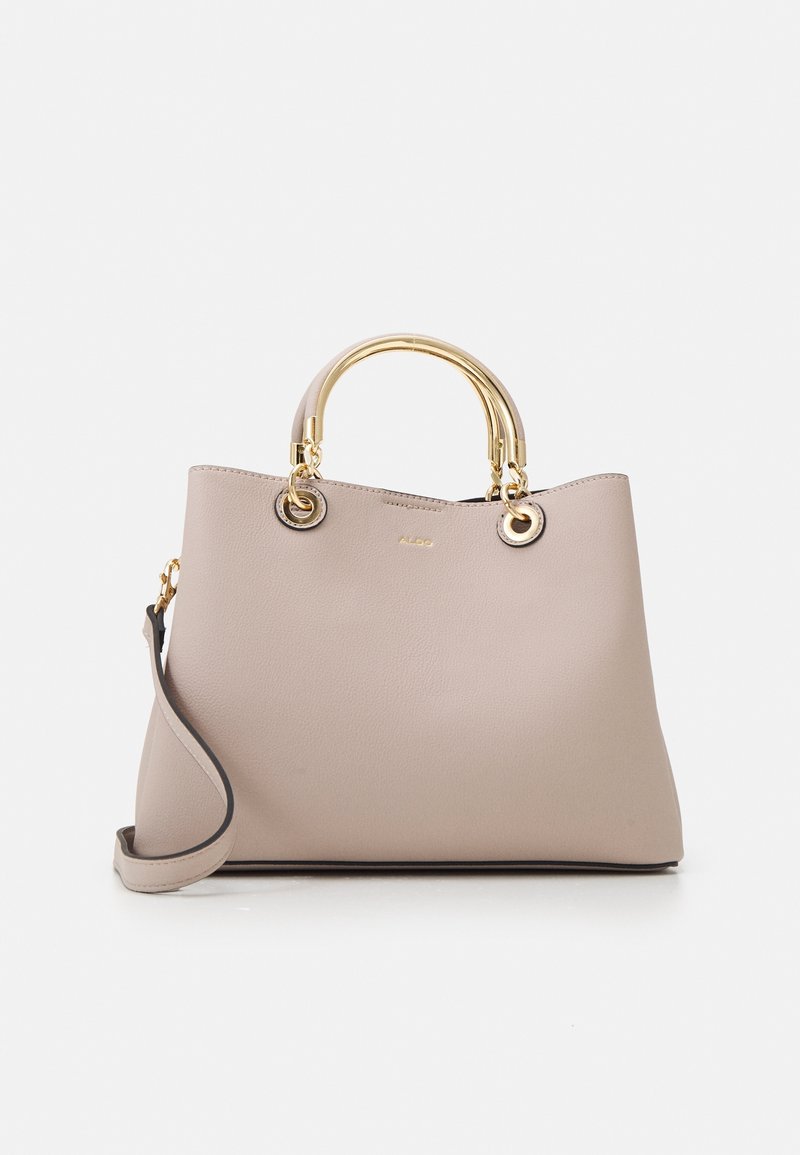 Sac à main beige avec des poignées métalliques dorées arrondies et une bandoulière réglable, présenté sur un fond blanc uni.