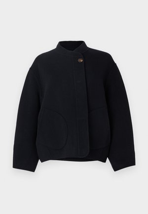 Black wool jacket with a stand collar, front button closure, and two large rounded pockets, featuring a relaxed fit and soft texture.