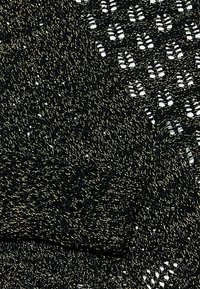 Țesătură tricotată neagră cu fire metalice aurii, prezentând diverse modele texturate. Design cu țesătură deschisă și o senzație moale, ușoară.