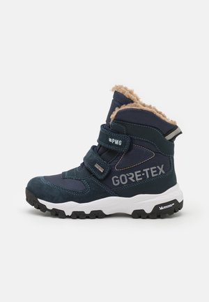 GORE-TEX gyermek téli csizma tengerészkék színben, plüss bézs béléssel, nubuk és textil anyagokkal, állítható pántokkal és mintás fekete gumitalppal.