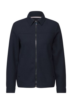 Veste bleu marine en tissu doux, avec une coupe droite, fermeture éclair devant et col, ainsi que des poches latérales.