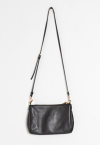 Borsa a tracolla in pelle nera con finitura testurizzata, hardware in tonalità oro e chiusura con zip. Include una tracolla regolabile.