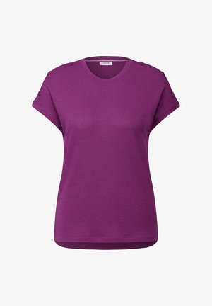 Lilla kortærmet t-shirt lavet af tekstureret stof, med rund halsudskæring og dekorative knapper på skuldrene.