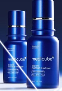 Blå cylindriska flaskor med silverdetaljer, märkta "Medicube One Day Exosome Shot 2000", innehållande vätska, båda i 30 ml storlek.