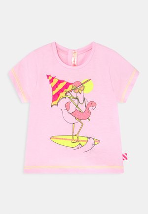 T-shirt rosa de manga curta com uma ilustração de tema de praia de um flamingo em uma prancha de surf, segurando óculos de sol e um guarda-sol, detalhada em cores vivas.