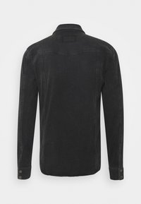 Svart denimskjorta med långa ärmar, spetsig krage och knappmanschetter. Har en ok-detalj på baksidan och en slät textur.