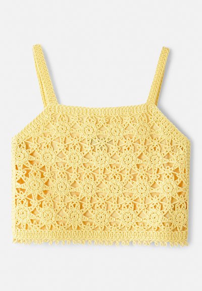 Top court au crochet jaune avec un motif en dentelle florale délicate, présentant des bretelles fines et ajustables ainsi qu'un ourlet à vagues.