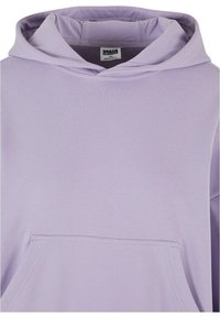 Sweat à capuche violet clair en matériau doux, avec une grande poche avant, des manches larges et une capuche ajustable avec cordon.
