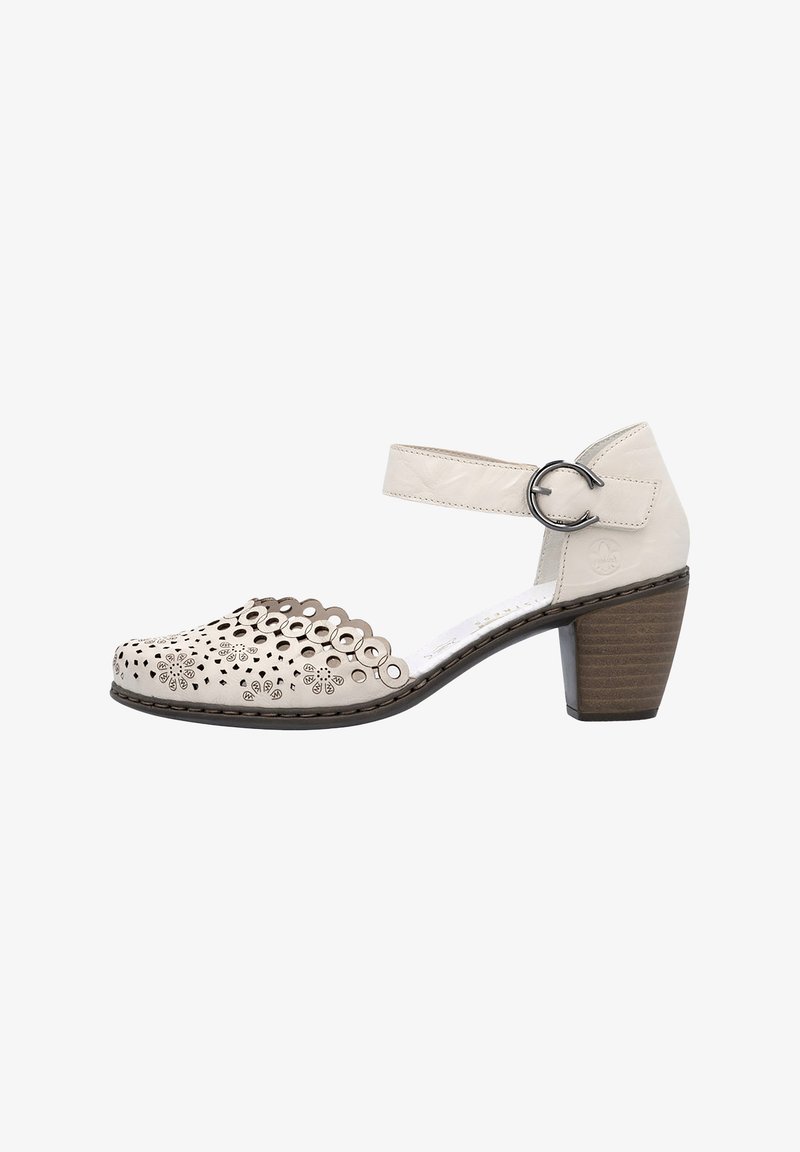 Chaussure à talon pour femme en cuir beige avec un motif floral perforé festonné à l'avant et une bride de cheville avec boucle ronde argentée.