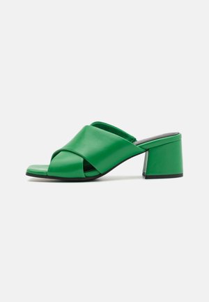 Grøn åben tå mule-sandal med brede overlappende remme og en chunky mellemhøj blokhæl.