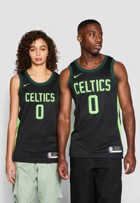 Svarte basketballtrøyer med teksten "CELTICS" i grønn og nummer "0". Har meshmateriale, skulderstropper og Nike-merke.