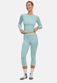 Himmelblaues Sportbekleidungs-Set, bestehend aus einem langärmligen Oberteil und knöchellangen Leggings. Glatte Textur mit dezenten Mustern und figurbetontem Schnitt.
