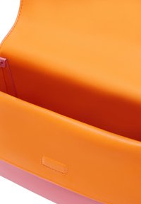 Oranssi nahkalaukku, jossa on sileä pinta, pinkillä pohjalla ja hienovaraisella sisätaskulla. Yksinkertainen, moderni muotoilu ja selkeät linjat.