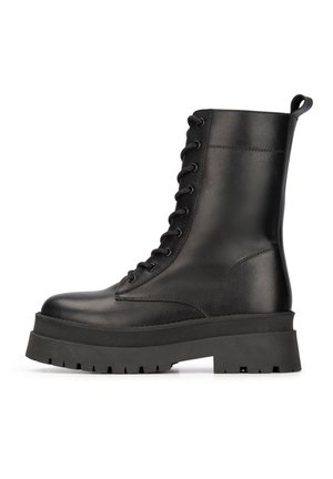 Botas de cuero negro hasta el tobillo con suela de plataforma gruesa, diseño de cordones y una lengüeta en el talón. Acabado mate con patrones texturizados.