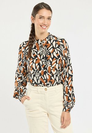 Blouse à manches longues avec un fond noir, ornée d'un imprimé de feuilles orange et crème. Encolure ronde avec détail de boutons et poignets froncés.
