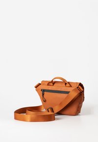 Borsa a tracolla in pelle arancione con tasca frontale con zip, manico arrotolato e tracolla regolabile, caratterizzata da una texture liscia e una forma triangolare.