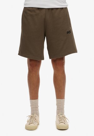 Shorts en coton marron avec une taille élastique, un ourlet plat et des poches latérales. Présentent un logo noir sur la jambe gauche.