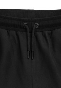 UNFAIR ATHLETICS CURVED - Tréningruha alsók - black