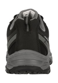 Musta vesitiivis vaelluskengät harmailla yksityiskohdilla, joissa on teksturoitu pohja, pehmustettu nilkkapehmuste ja vetotappi helppoa pukemista varten.