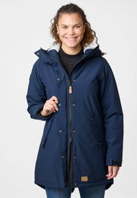 Granatowa ocieplana parka z zapięciem na zamek, guzikami, kapturem i kieszeniami bocznymi. Posiada szare polaru w środku i skórzane akcenty.