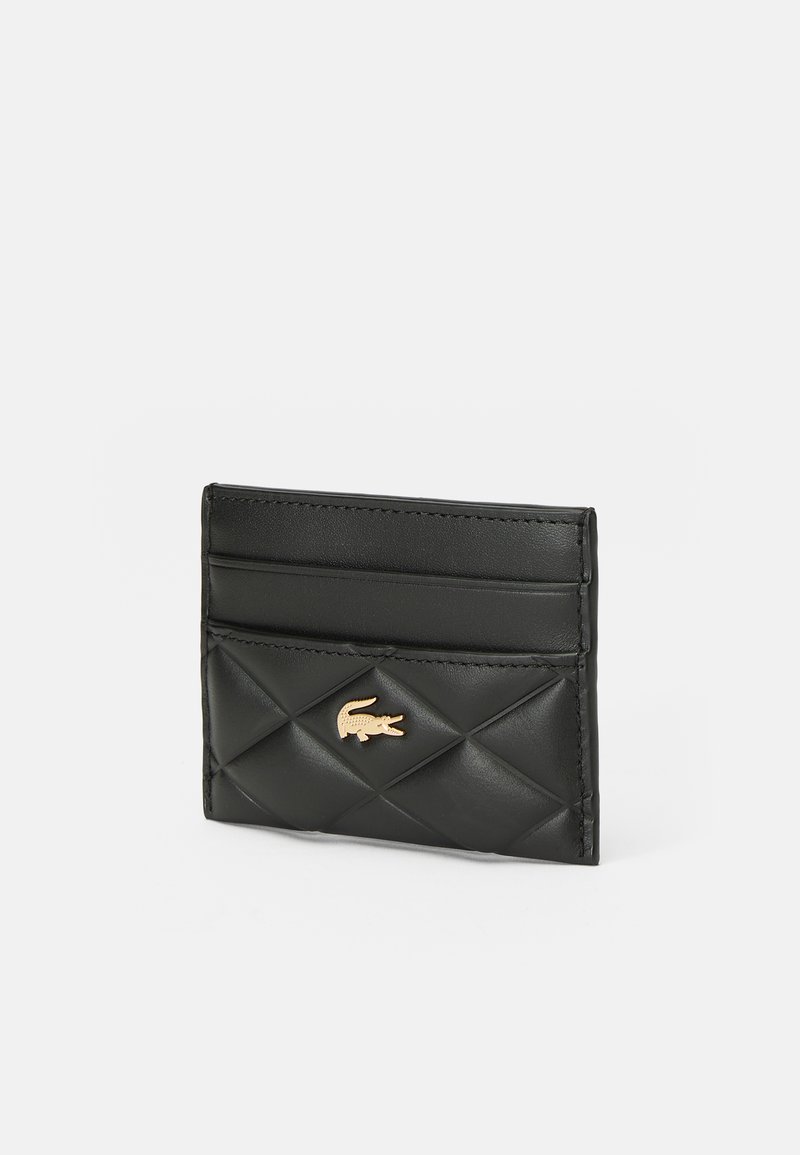 Porte-cartes en cuir noir avec un motif de losanges matelassés et un logo en croco doré centré sur le devant, présentant deux fentes pour cartes sur le dessus.