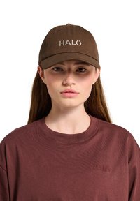 Brown baseball cap with embroidered "HALO" logo; paired with a maroon crewneck shirt featuring a smaller logo. Soft fabric, casual design.