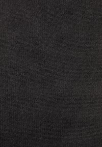 Tissu noir texturé avec un tissage fin, présentant une finition mate. Le matériau est doux et dense, adapté à la tapisserie ou aux vêtements.
