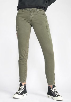 Pantalons cargo vert olive au design slim fit, dotés de poches latérales et d'une fermeture éclair, associés à des baskets montantes noires.