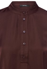 Brązowa koszula z kołnierzykiem, zapinana na cztery ciemne guziki z przodu, wykonana z gładkiej tkaniny o lekkim połysku, o czystym, dopasowanym kroju.