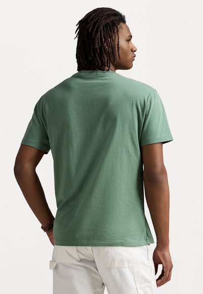 Zeleni pamučni T-shirt s okruglim izrezom, kratkim rukavima i ležernim krojem. Tkanina izgleda mekano s blagom teksturom.