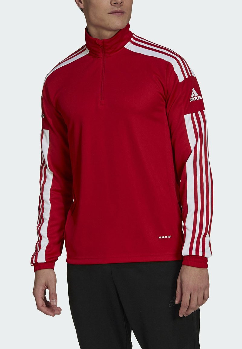 Red long-sleeve athletic top with a quarter zip, white three-stripe design on sleeves, made from moisture-wicking fabric, featuring "AEROREADY" branding.