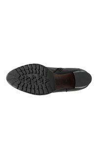 Suola di scarpa nera con un battistrada sagomato per il grip, design elegante e bordi smussati con un accento in legno vicino al tallone.