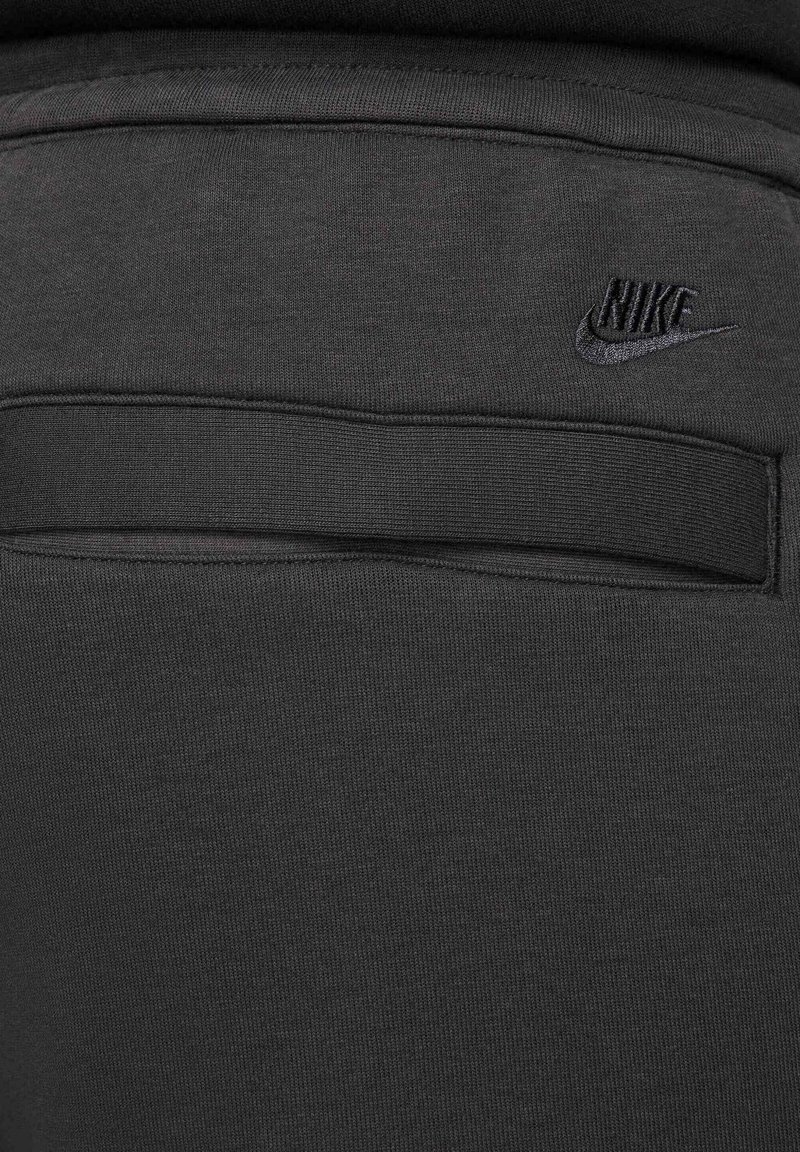 Czarne szorty sportowe z miękkiego materiału, z tylną kieszenią o płaskim designie i subtelnie haftowanym czarnym logo Nike.