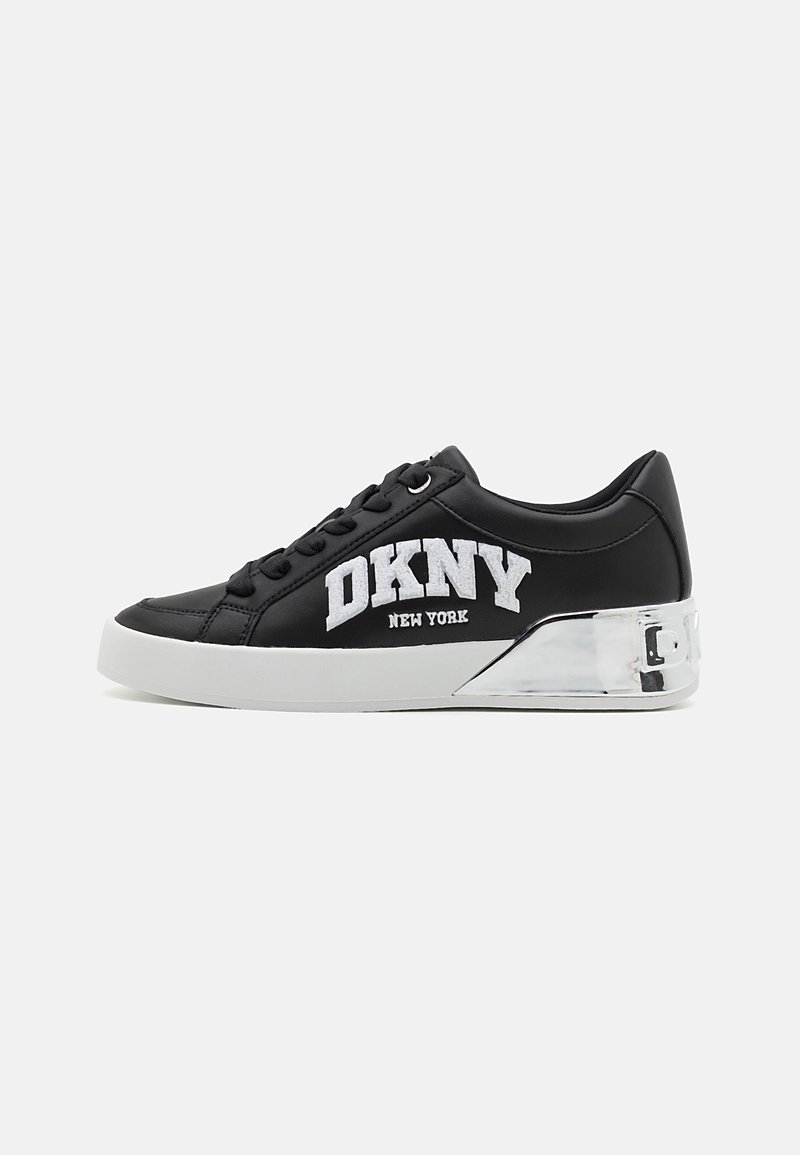 Baskets basses noires avec logo blanc "DKNY New York", lacets noirs, semelle blanche et détail talon argenté réfléchissant.