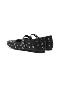 Bailarinas de cuero negro con múltiples ojales plateados, punta redonda y correas cruzadas para un ajuste seguro. Textura suave, tacón bajo.