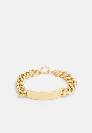 Bracelet en chaine en or avec une plaque centrale plate et lisse ainsi que des maillons entrelacés. La surface est brillante avec une finition polie.