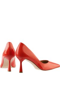 Red patent leather high heels with a pointed toe, slender stiletto heel, and a cut-out back heel design. Smooth, glossy finish.