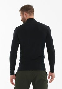 Zwart langmouw sportshirt met hoge kraag, gemaakt van gladde, rekbare stof. Voorzien van raglanmouwen voor verbeterde bewegingsvrijheid.
