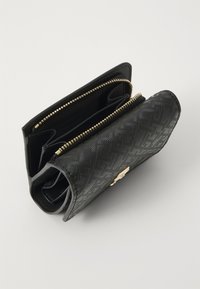 Zwarte leren portemonnee met een gestructureerd patroon, gouden rits en meerdere compartimenten voor kaarten en contant geld, met een slank design.