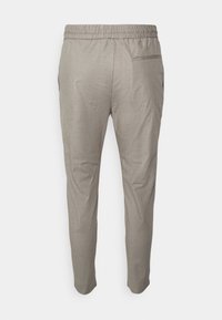 Pantalones tapered gris claro con cintura elástica y bolsillo trasero, mostrados desde atrás sobre un fondo blanco.