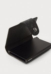 Black cardholder with a textured leather exterior and snap closure. Features a sleek, matte black interior and subtle branding.