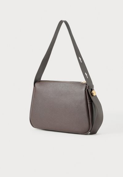 Brun läderhandväska med en strukturerad design, slät yta och ett kontrasterande mörkt band. Utrustad med en guldfärgad dragkedja och accentknapp.