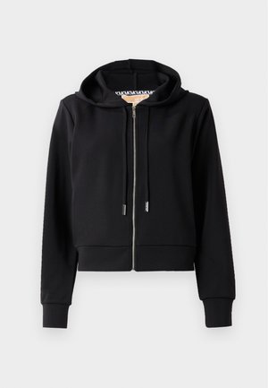 Crni skraćeni dukserica izrađena od mekog materijala, s prednjim zipom, kapuljačom na vezanje i rebrastim manžetama. Glatka tekstura s minimalnim detaljima.