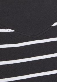 Tessuto nero con strisce bianche orizzontali, caratterizzato da una texture liscia e un dettaglio a scollatura a V.