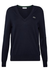 Pull à col en V bleu marine à manches longues avec poignets et ourlet côtelés, arborant un petit logo crocodile vert sur la poitrine gauche.