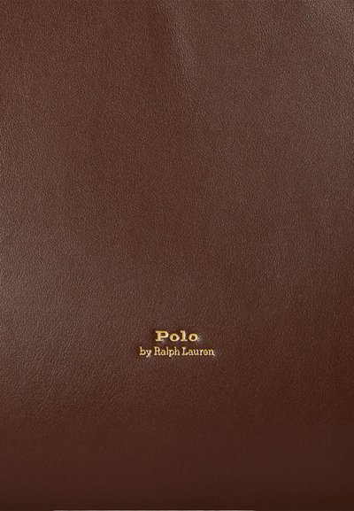 Brūna ādas maks ar teksturētu virsmu. Apakšējā labajā stūrī iemirdzams reljefais "Polo by Ralph Lauren" zīmola uzraksts zelta krāsā.