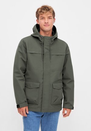 Grüne wasserdichte Jacke mit Kapuze, frontalem Reißverschluss und zwei großen Seitentaschen. Besitzt eine lockere Passform und verstellbare Kordeln.