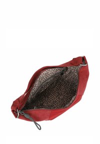 Clutch bag in suede rosso con chiusura a zip. L'interno presenta una fodera in tessuto scuro con un motivo chiaro. Include una tracolla decorativa.