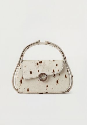 Kleine beige Handtasche mit dunkelbraunen Flecken, runden Griffen und einem runden Metallverschluss auf der vorderen Klappe.