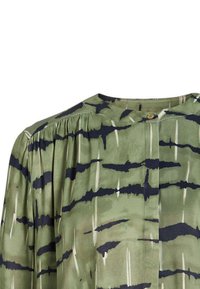 Blouse verte en tissu léger avec fermeture à boutons, présentant un motif rayé en bleu foncé et crème, et des détails plissés aux épaules.